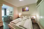 Modernes Schlafzimmer mit Bett und angrenzendem Wohnbereich