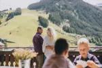 Paar vor Bergen mit einem Tisch und einem Kind im Vordergrund