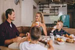 Familie beim Frühstücken am Tisch in einer modernen Küche
