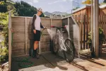 Mann steht in einem Fahrradabreitsbereich neben einem Fahrrad