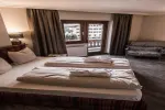 Gemütliches Hotelzimmer mit zwei Betten und großen Fenstern