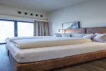 Hotelzimmer mit zwei Betten und großem Fenster