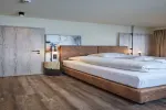 Hotelzimmer mit großem Bett und Holzboden