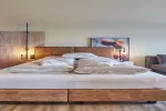 Modernes Schlafzimmer mit großem Holzbetten und warmer Dekoration