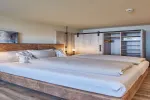 Ein geräumiges Schlafzimmer mit Holzmöbeln und einem Schrank.