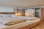 Modernes Schlafzimmer mit zwei Betten und Holzmöbeln
