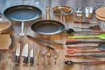 Küchenutensilien und Töpfe auf einer Holzoberfläche