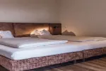 Modernes Schlafzimmer mit einem großen Holzbett und weißen Bettlaken