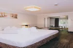 modernes Hotelzimmer mit großem Bett und minimalistischer Einrichtung