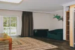 minimalistisches Wohnzimmer mit dunklem Sofa und Holzboden
