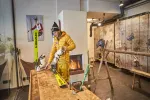 Person bereitet Getränke an einem Holztresen in einem Innenraum vor
