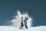 Zwei Snowboarder erzeugen einen Spritz auf dem Schnee