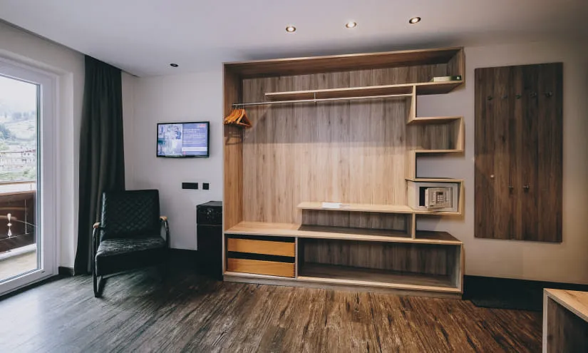 Moderne Zimmer mit Holzregal, Fernseher und Stuhl.