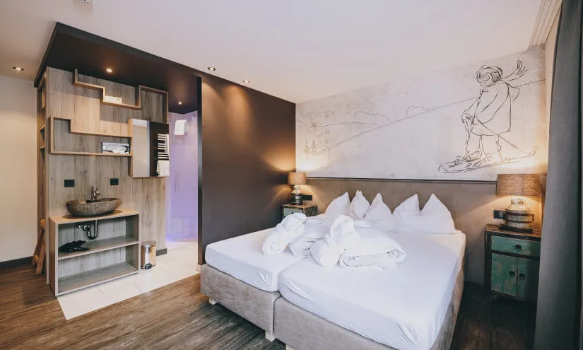modernes Hotelzimmer mit zwei Betten und künstlerischer Wandzeichnung