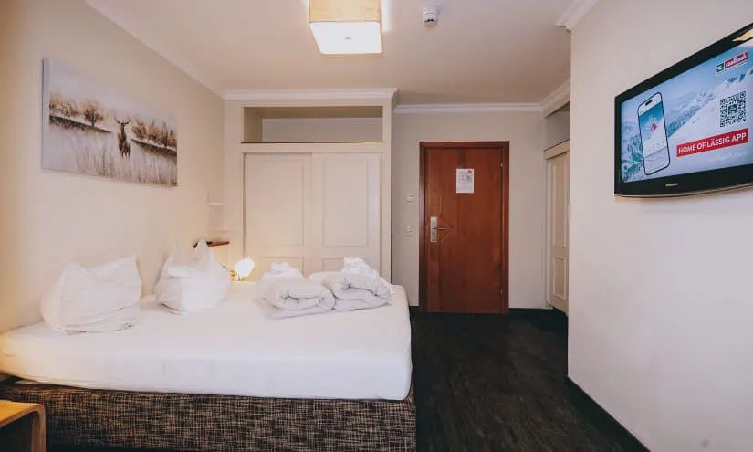 Modernes Hotelzimmer mit einem Bett, Fernseher und Kunstwerk an der Wand