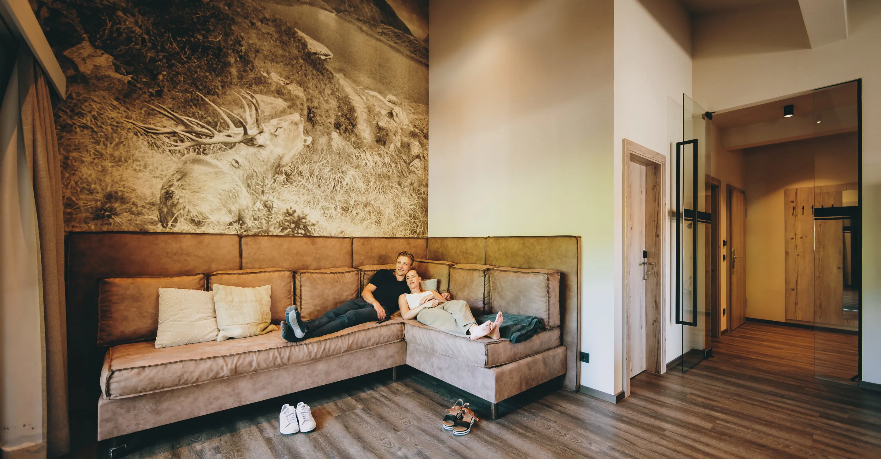 Wohnzimmer im Thomsn Hinterglemm mit Sofa und dekorativem Wandbild