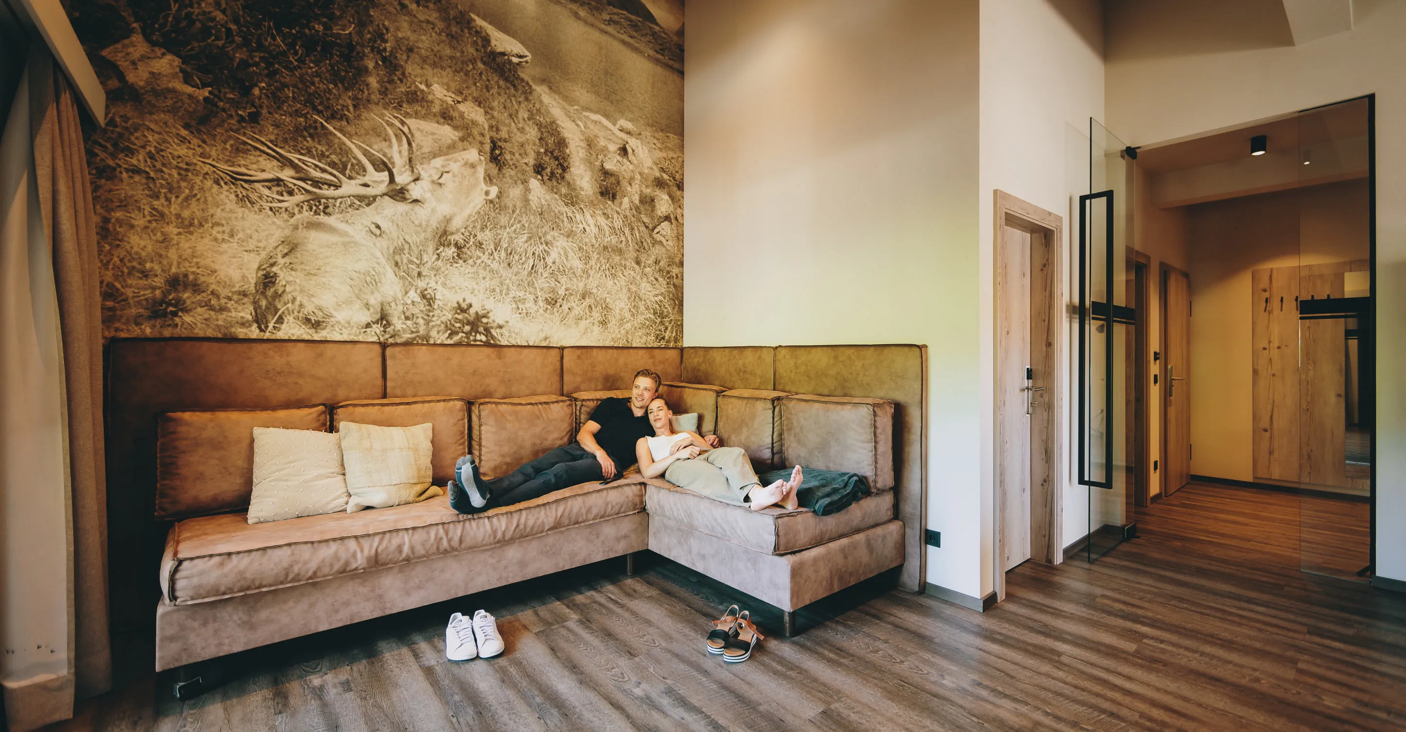 Gemütliches Apartment mit einem Sofa und Holzfußboden, zur Seite ein offener Flur.