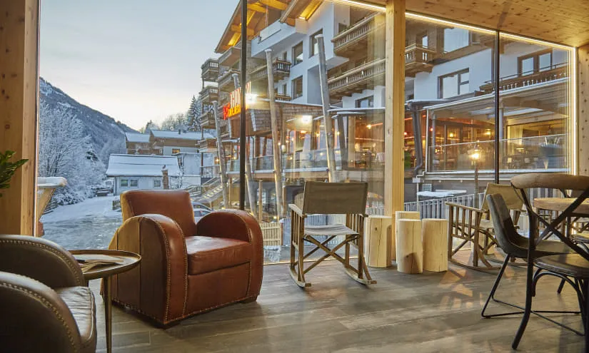 Innenansicht einer gemütlichen Alpenlodge mit schneebedeckter Landschaft