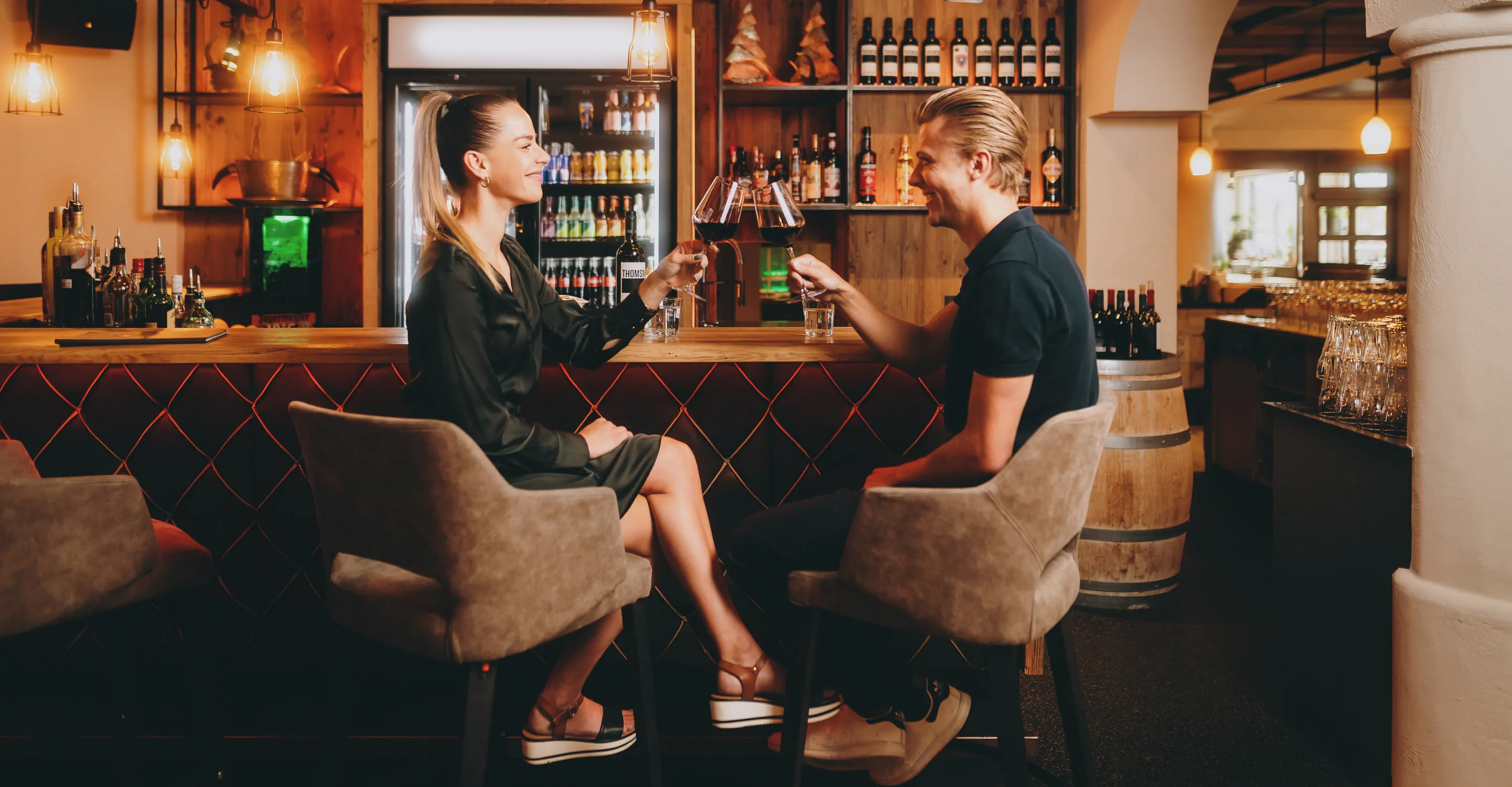 Zwei Personen in einer Bar in Thomsn-Hinterglemm mit Getränken.