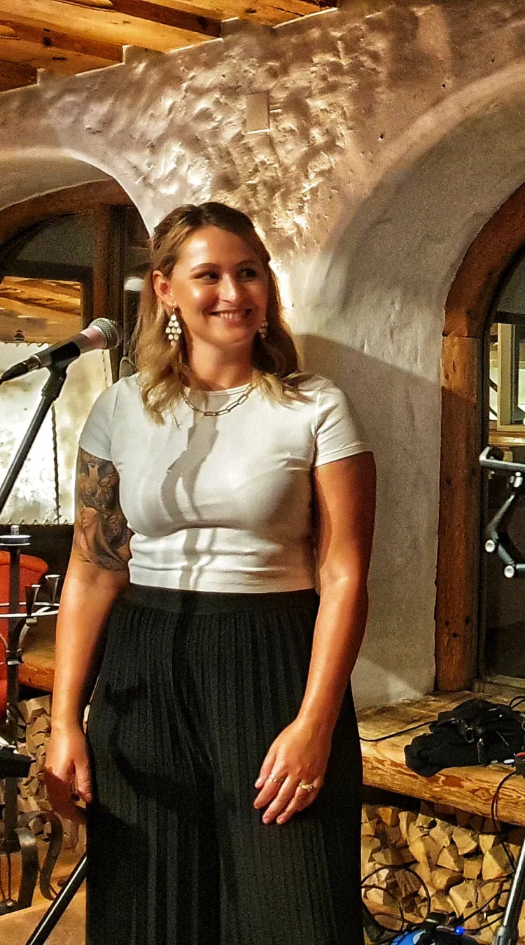 Musikduo auf der Bühne, einer mit Gitarre, Holzstruktur im Hintergrund