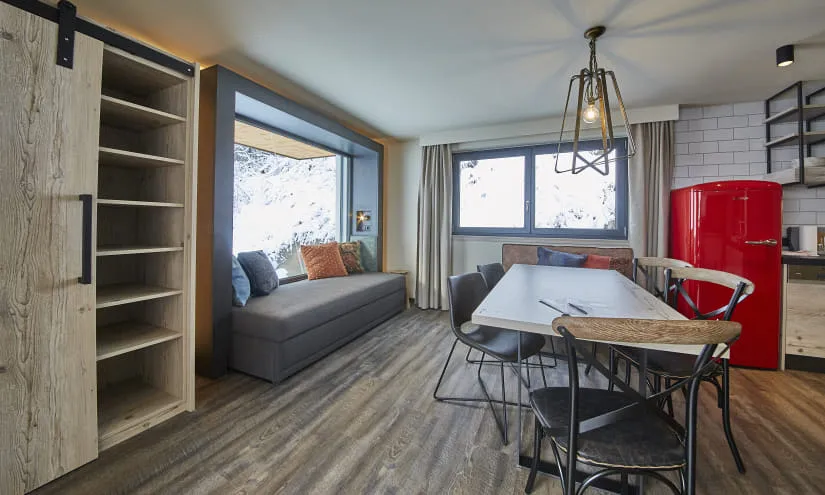 Moderne Wohnbereich mit Sofa, Esstisch und rotem Kühlschrank