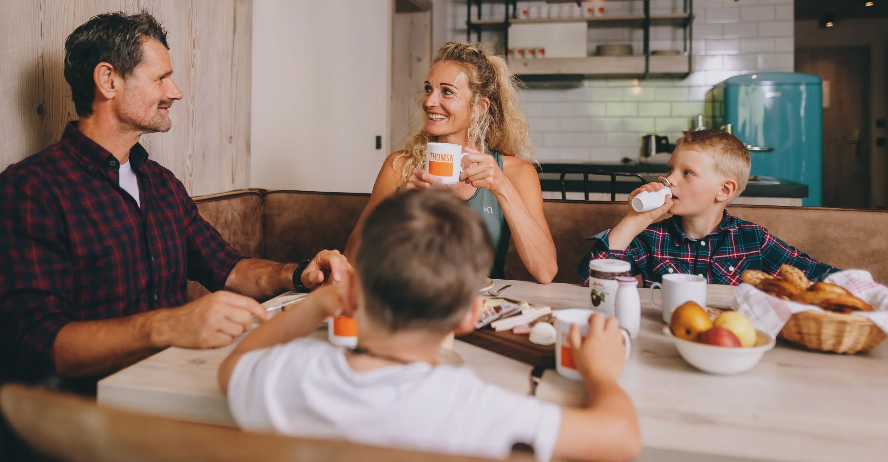 Familie genießt gemeinsam das Frühstück an einem Tisch mit Essen und Getränken