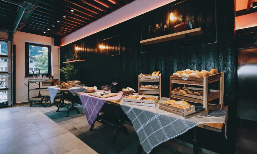 Frühstücksbuffet mit Brotkörben und Tischen in modernem Raum