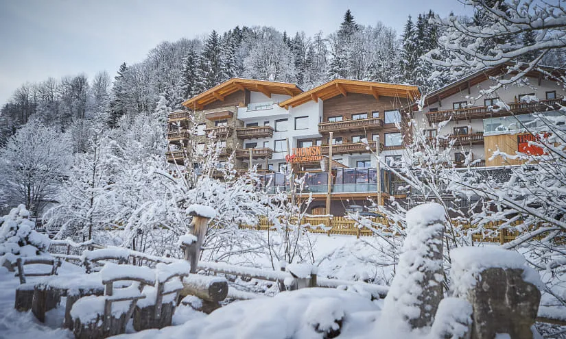 Schneebedeckte Landschaft mit modernen Chalets im Vordergrund