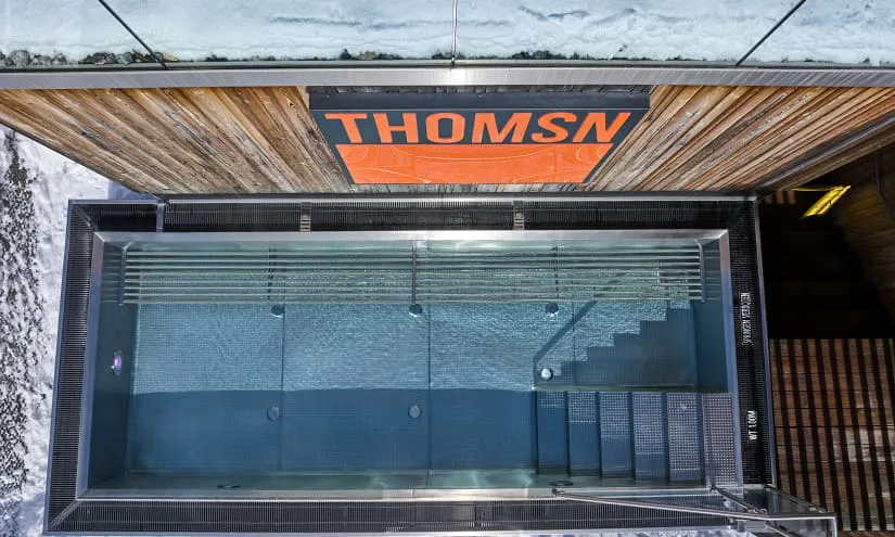 Luftaufnahme eines Pools mit Treppe und THOMSN-Schild