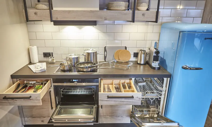 Moderne Küche mit Herd, Kühlschrank und offenen Schubladen