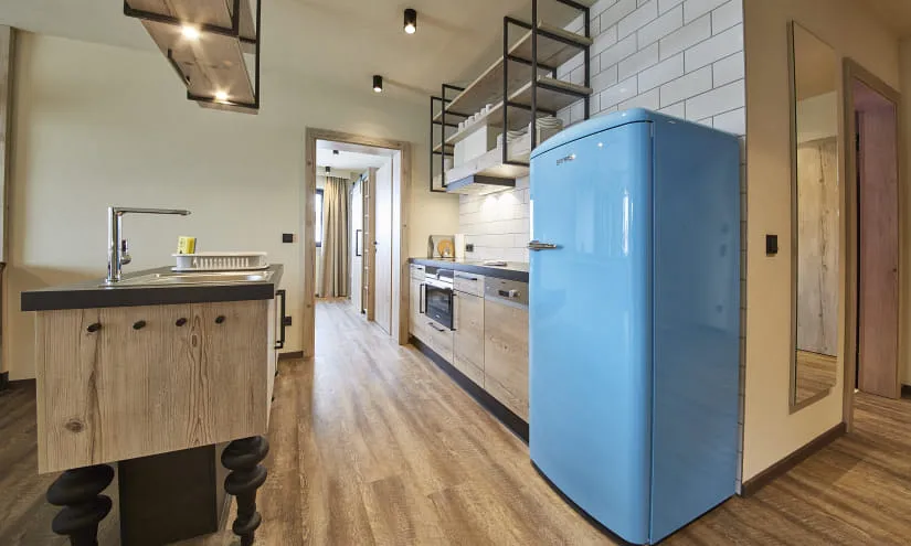 Moderne Küche mit blauer Kühlschrank und Holzregalen