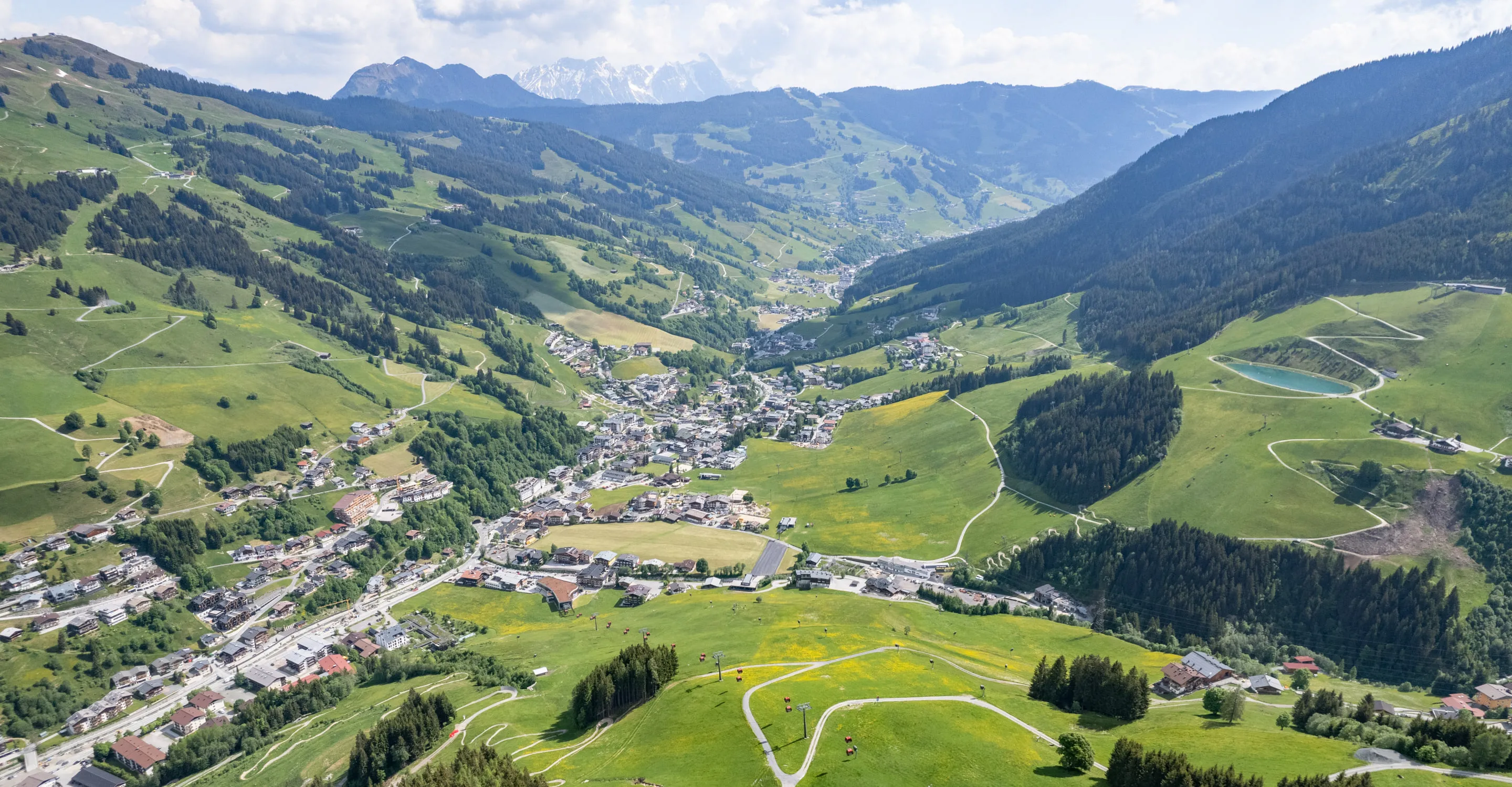 Luftaufnahme des Tals von Hinterglemm mit Bergen und Dorf