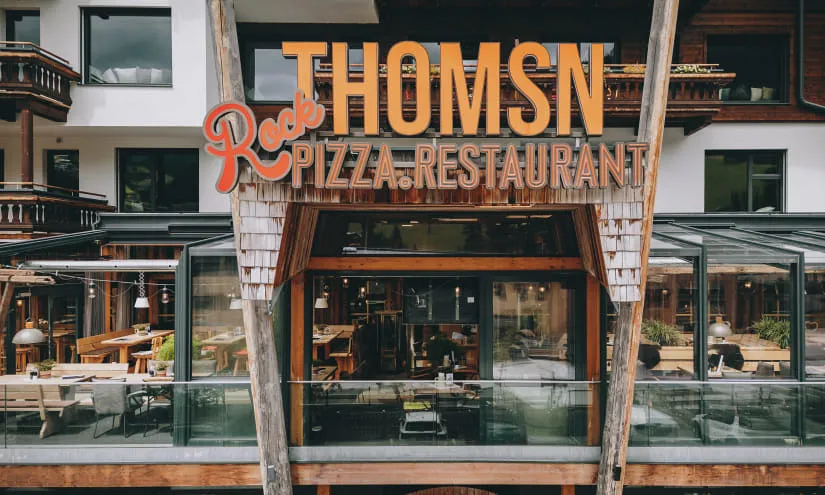 Restaurant Thomsn mit Holzveranda und großen Fenstern